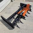 Wolverine box blade from above, orange 3-point hitch tower over black frame and ripper shanks