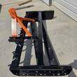 Wolverine box blade from above with ripper shanks raised, orange hitch and bolted cutting edge