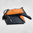 Black and orange brush cutter, angled view, orange motor cover and hydraulic hose couplers at the left