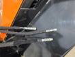 Three black hydraulic hoses with metal couplers running along the black steel frame
