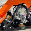 Hydraulic motor on the Wolverine E-VPC06 plate compactor, steel lines and sleeved hoses bolted to the housing
