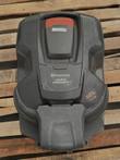 Husqvarna Auto Mower seen from above with alarm sticker, docked on its charging base