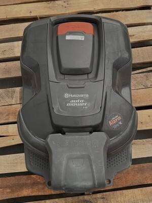 Husqvarna Auto Mower seen from above with alarm sticker, docked on its charging base