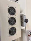 Three cooling fans with metal guards on the induction sealer housing, with a height clamp knob beside