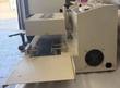 Cream induction cap sealer from the side: conveyor belt, sealing head and rear cooling fan