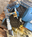 Hydraulic hose end, brass block and valve fittings next to the motor, shot from above