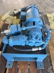 Blue hydraulic power unit with electric motor and gear pump in a steel drip tray on a pallet