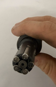 Hand holding the blade end of an expanding reamer, blades arranged around a center bore