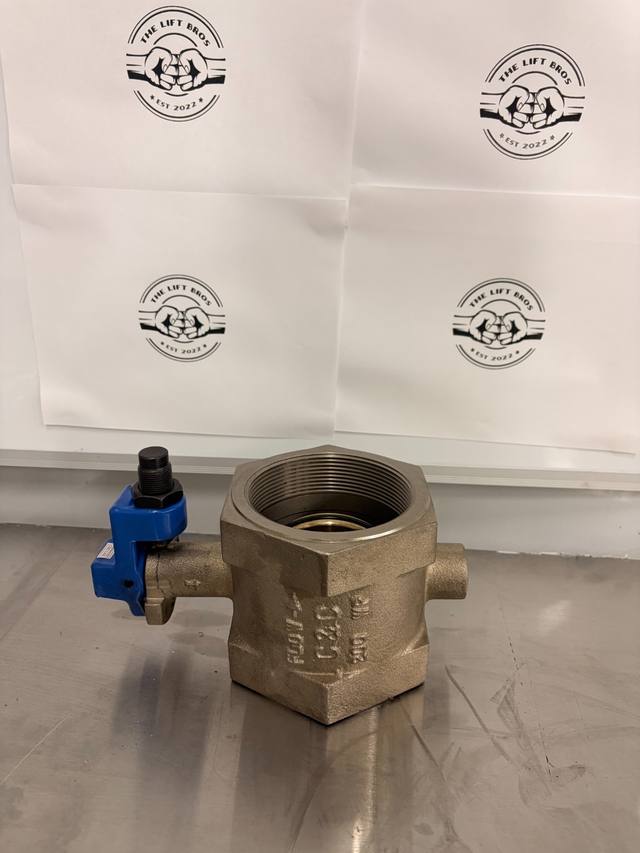 Bronze-colored threaded butterfly valve, side with cast flow arrow and C&C mark, blue stop bracket at left
