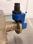 Blue stop bracket and black threaded stem on the side port of a bronze-colored butterfly valve