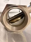 Inside the threaded bore of a butterfly valve, showing the round disc and shaft