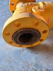 Flange face and bore of a yellow Class 900 check valve, bolt holes, chipped paint, light rust inside