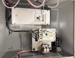 Inside the open Eaton DG1 enclosure: white PowerXL DG1 drive, circuit breaker, relays and terminal blocks