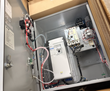 Open Eaton PowerXL DG1 enclosure showing the white drive, circuit breaker and wiring inside a cardboard box