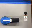 Blue and black rotary disconnect handle on the gray Eaton drive door with a hazardous voltage warning label