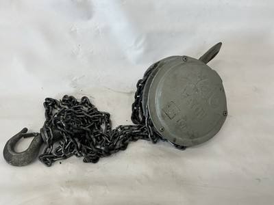 Gray Yale manual chain hoist lying on its side with the load chain and bottom hook