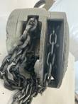 Load chain running through the open side of a gray Yale hoist body, with the top hook above