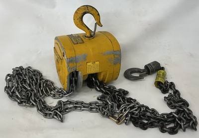 Yellow Budgit chain hoist hanging from its top hook with the load chain and bottom hook spread out