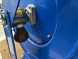 Brass swivel inlet with yellow caution label on blue hose reel hub, rust on the fitting