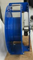 Blue steel hose reel seen edge-on, guide rollers at top and swivel at the hub