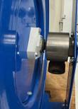 Swivel inlet fitting on the hub of a blue hose reel, side view