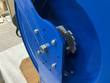 Ratchet gear and bolted side plate on a blue spring-driven hose reel