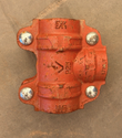 Red four-bolt grooved coupling with a side branch outlet, marked 1 1/2 and P25