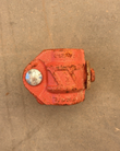 Top of a red ductile iron pipe coupling housing with cast markings and a bolt head
