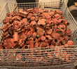 Top-down view of a wire basket full of red grooved couplings, tees and fittings
