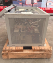 Gray charger cabinet on a pallet, perforated side panel with the door latch open at top