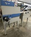 Two-section shrink wrap system on casters, tunnel with blue top at left and sealer at right