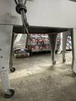 Steel legs with locking casters under the shrink wrap machine frame, power cord hanging above
