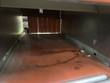 Inside of the shrink tunnel, looking down the heated chamber with orange curtain at the far end