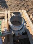 Stainless steel bellows and cast flange with bolt lugs on a pallet, beside a second bellows