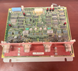 General Electric circuit board with red faceplate, four round connectors, red LEDs and ICs on a wood table