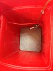 Top-down view into the empty red ice bin with gray insert plate, gas hose and keg coupler