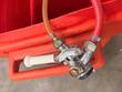 Chrome keg coupler with white handle, red gas hose and amber beer line