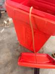 Red cart with lid open, amber beverage line over the side and embossed side panel