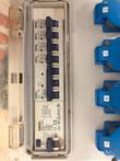 Open panel with a row of circuit breakers and a residual-current switch, blue sockets numbered 3 to 6 at right