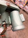 Green motor on a bracket beside the belt housing and bearing on the saw head