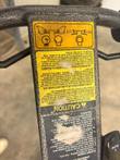 Danger carbon monoxide decals in English, Spanish and French on a floor buffer handle, QR code below
