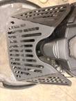 Black slotted steel shroud around the engine of a propane floor machine, seen from above