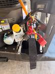 Engine side with tach/hour meter reading 165.8, oil cap, relay, red battery cable and empty battery tray