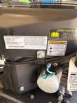 Engine emission label with engine maintenance and warning decals above a white oil filter