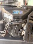 SAFR Technology logo and emission test record label on a black engine cover above fuel hoses