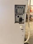 Power inlet and fan vent on the cabinet, with a white cord running down the side