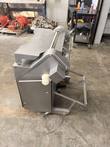 Rear three-quarter view of a stainless steel meat tenderizer with feed rollers and a tilted frame, on casters