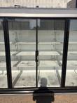 Center glass doors of the merchandiser cooler with empty white shelves and black door frames