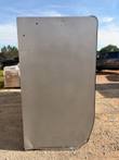Opposite end of the glass door merchandiser cooler, gray steel end panel with a few small dents