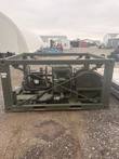 Olive-green military fuel transfer pump skid from the side, hose reel at right